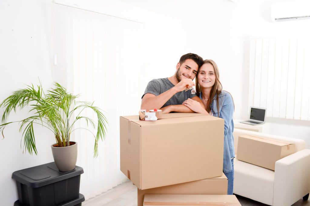 First-time homebuyer couple with boxes and keys