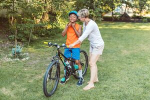 woman helping boy ride a bike